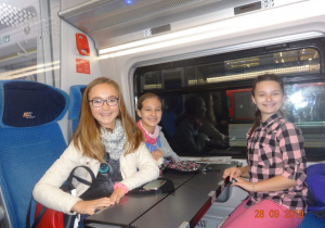Dziewczynki jadą pociągiem do Warszawy.