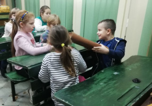 Dzieci w ławkach w Muzeum Oświaty.