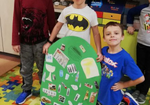 Dzieci pokazują plakaty dotyczące segregacji śmieci.
