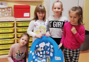 Dzieci pokazują plakaty dotyczące segregacji śmieci.