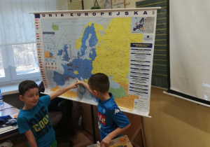 Chłopcy pokazują na mapie, gdzie leżą Włochy.