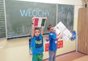 Chłopcy trzymają w ręku flagę Włoch.