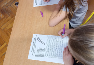 Uczniowie odwzorowują piękne pismo.