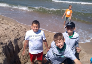 Chłopcy z IIId kopią dół na plaży.