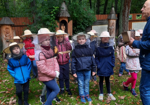 Uczniowie w ochronnej siateczce przed pszczołami.