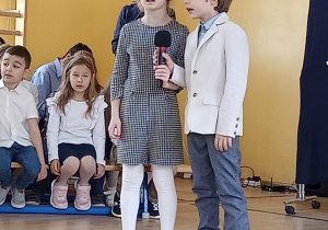 Dwoje uczniów z klas pierwszych śpiewa piosenkę.