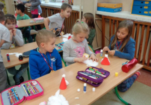 uczniowie IId pomagają robić Mikołaje z papieru