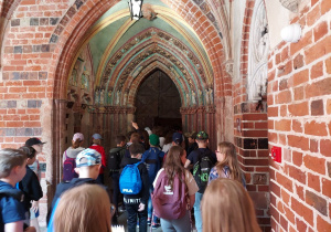 Uczniowie zwiedzają zamek w Ostródzie, poznając cechy architektury średniowiecznej.