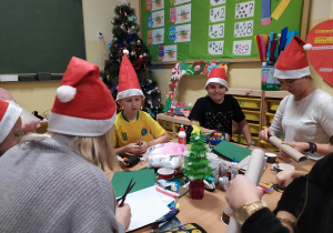 Uczniowie klasy 3c wraz z rodzicami wykonują ozdoby świąteczne.