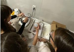 Uczniowie przygotowujący mydełka pod okiem nauczyciela chemii.