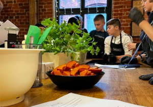 Uczniowie i nauczyciele biorący udział w warsztatach kulinarnych