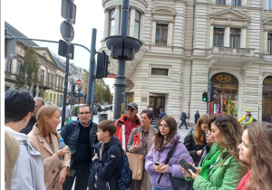 Uczniowie i nauczyciele biorący udział w zwiedzaniu ulicy Piotrkowskiej w Łodzi.