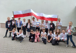 Uczniowie klasy pokazują flagę, którą wspólnie wykonali.