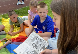Uczennice klas starszych czytają fragment książki świetliczakom